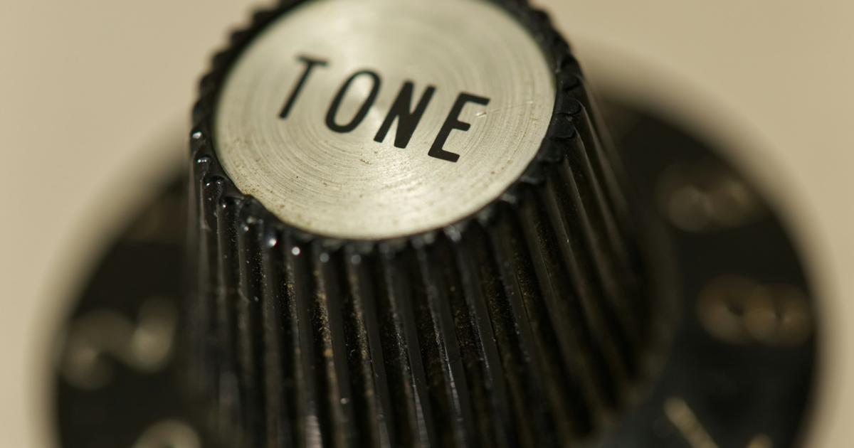Close-up of a black TONE control knob on a numbered dial.