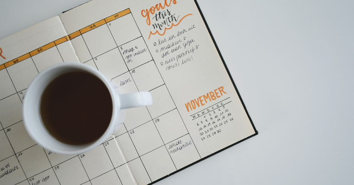White coffee mug on an open November planner.