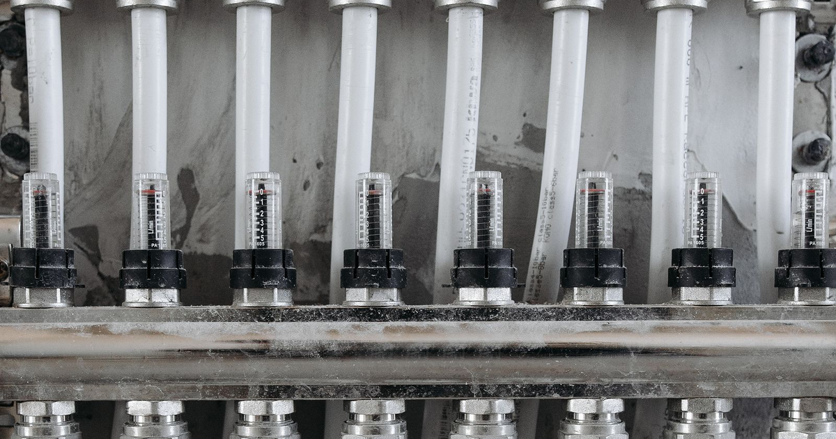 White plumbing manifold with a row of flow meters.